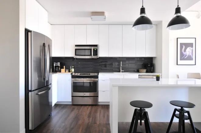 Design reference: white flat-panel kitchen cabinets with a dark subway tile backsplash, a two-seat island
