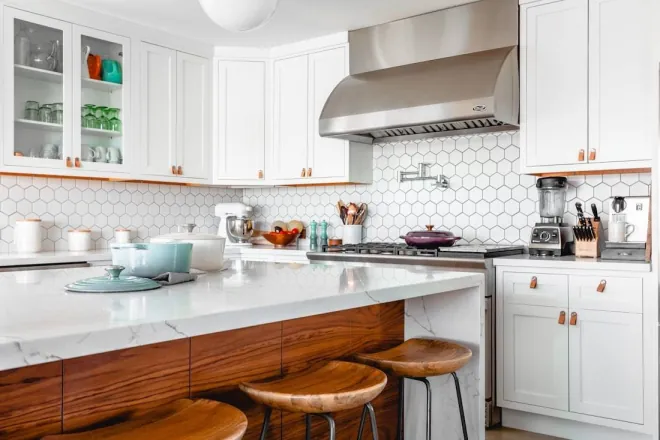 Design reference: white kitchen with a hexagon tile backsplash, a wood-fronted island with three stools