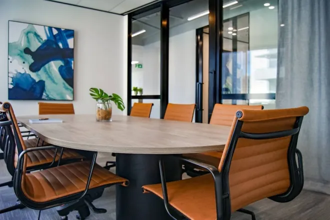 Design reference: commercial meeting room with a glass partition wall, an oval table, tan leather chairs