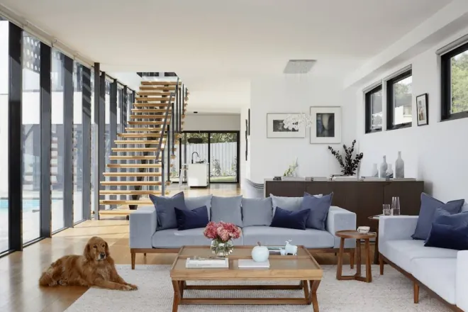 Design reference: open-plan living room with a full-height glass wall, an open-riser staircase